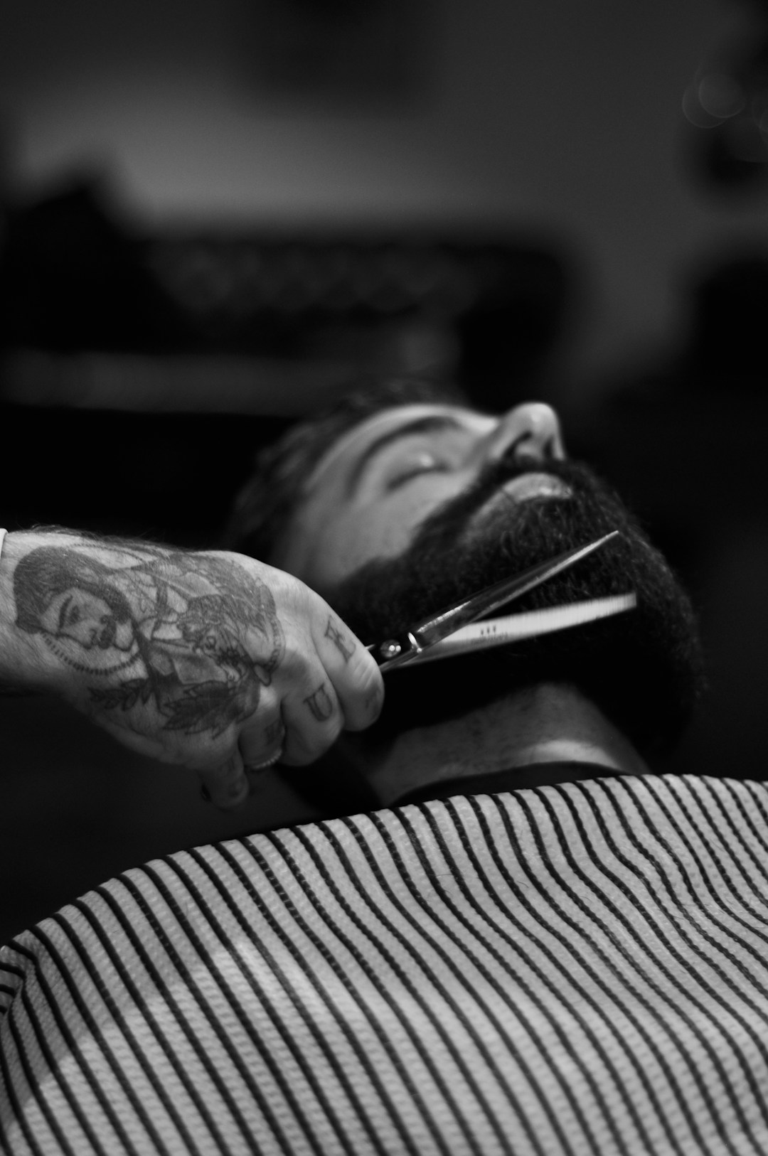 Barba sendo aparada com tesoura, em preto e branco